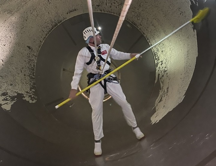Rope access specialist voert reinigingswerkzaamheden uit in een besloten ruimten