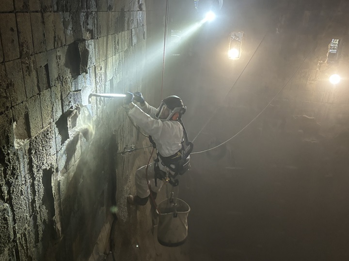 Rope access specialist voert veiligheidsreiniging uit in een afvalverbrandingsinstallatie